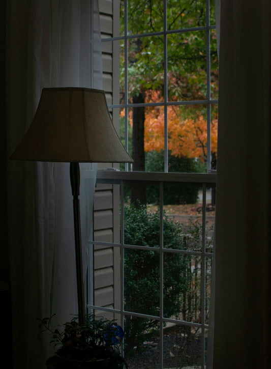 a lamp sitting on a table next to a window