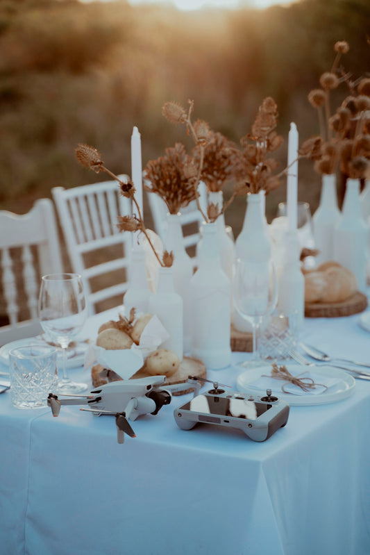 A table with a white table cloth and white chairs