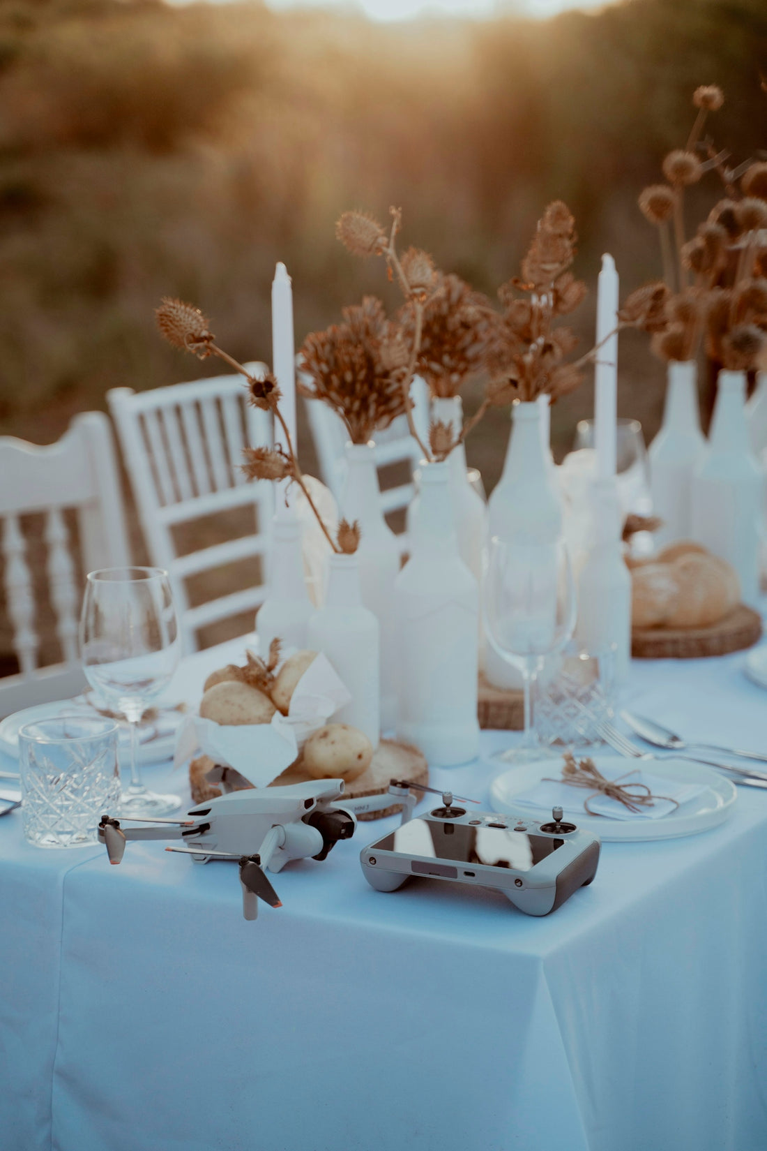 A table with a white table cloth and white chairs
